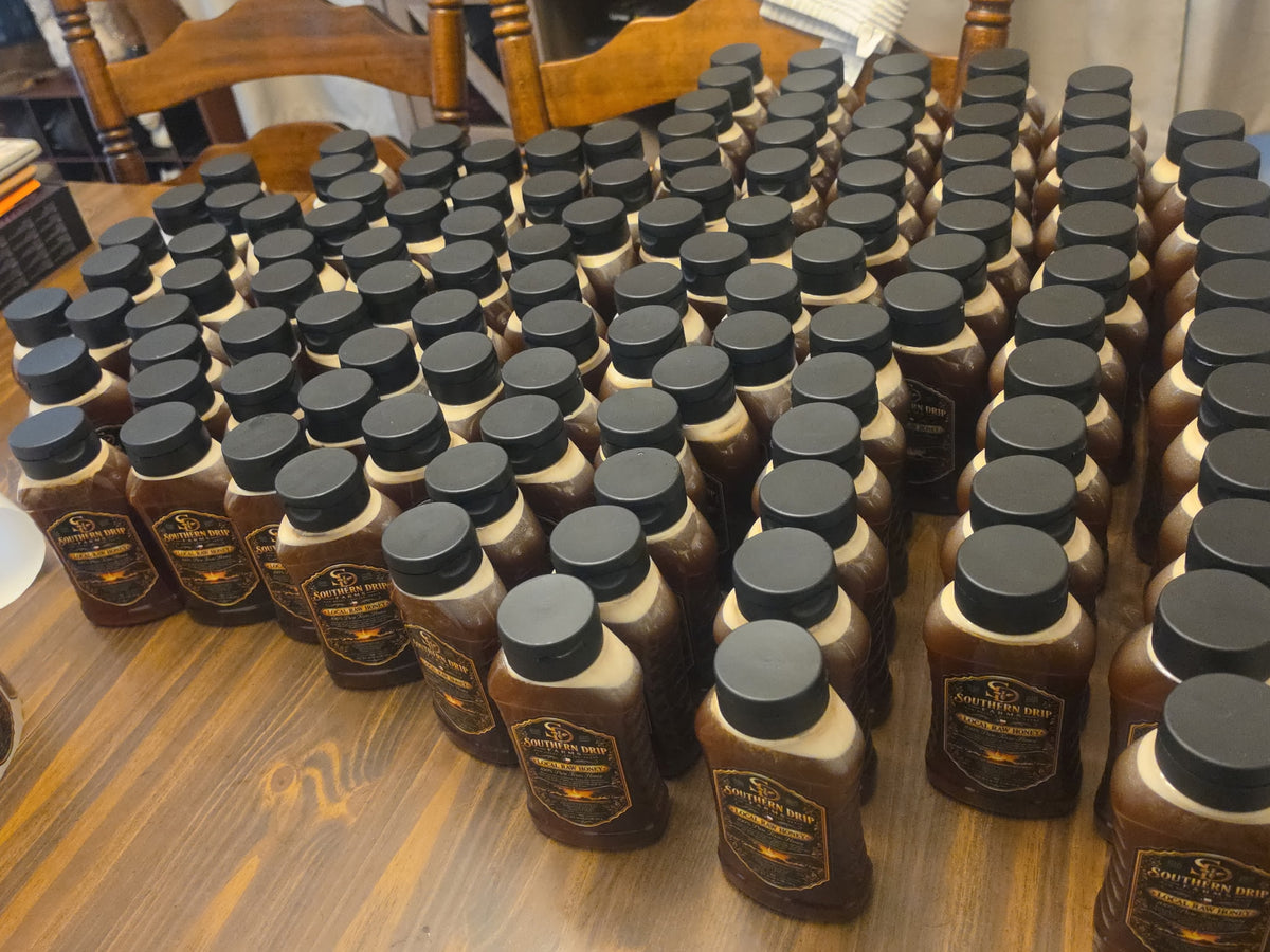 Rows of filled and labeled Southern Drip Farms honey bottles